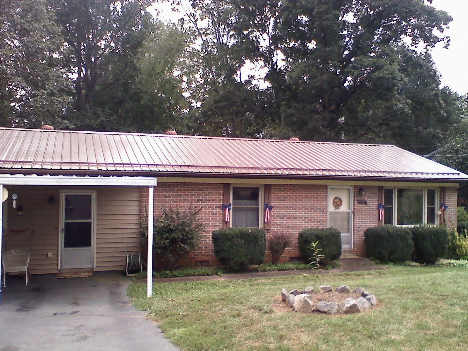 Bronze metal roof and carport on a brick ranch home — Roof Repair work by our crew in Jbsa Randolph