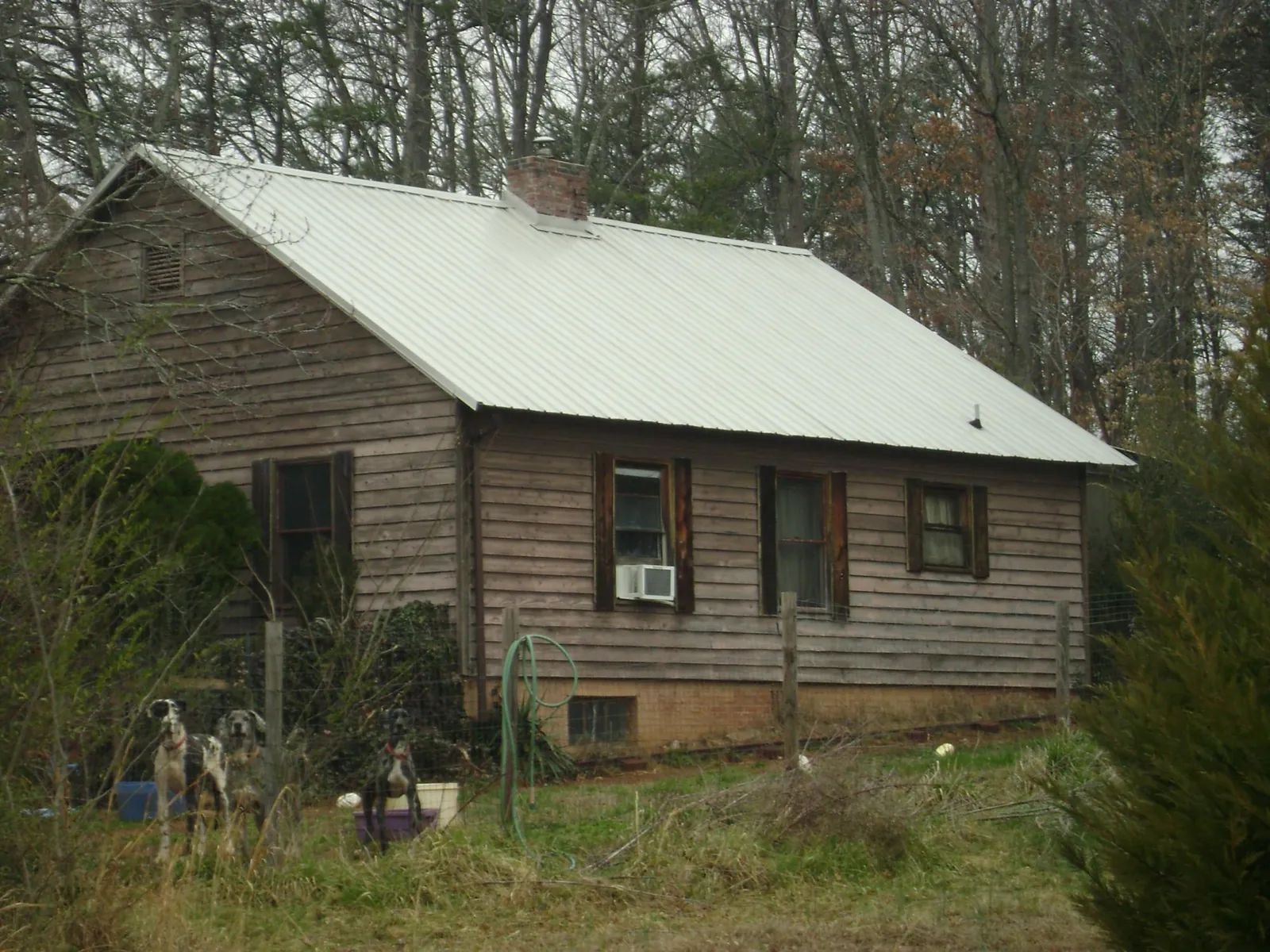 White metal roof on an old wood sided farmhouse, from a Metal Roof Installation job in Jbsa Randolph